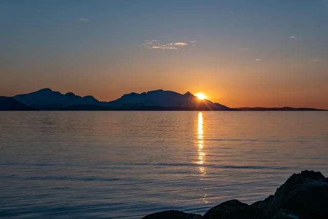 The midnight sun over the island of Reinøya in the Ullsfjord in Norway